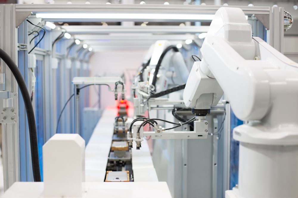 roboty przemysłowe pracujące przy linii produkcyjnej