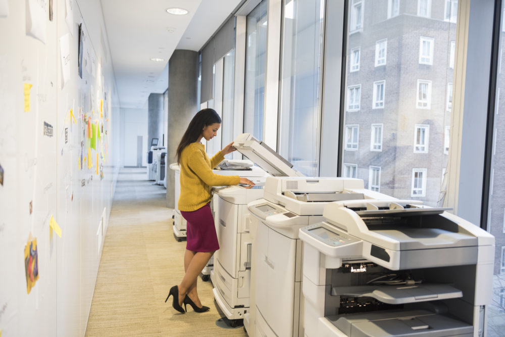 kobieta stojąca przy drukarce