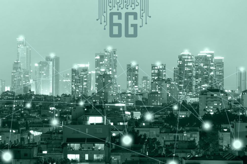 miasto, poszczególne budynki są połączone liniami symbolizującymi sieć komunikacyjną, powyżej napis "6G"
