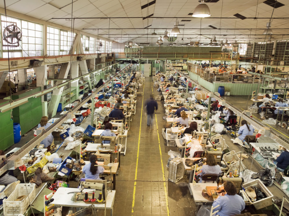 ludzie pracujący w fabryce obuwia