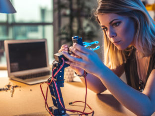 Young woman working in a robotics workshop.